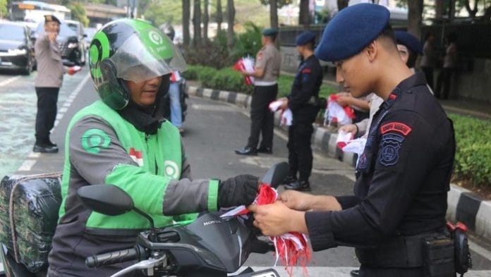 Jelang HUT RI, Brimob Polda Metro Bagikan 5.000 Bendera Merah Putih kepada Pengendara